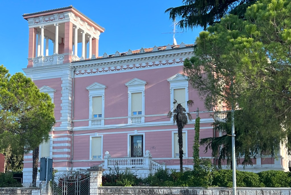 Pastel pink mansion near the Old Town of Croatia's Rovinj across from the harbor.