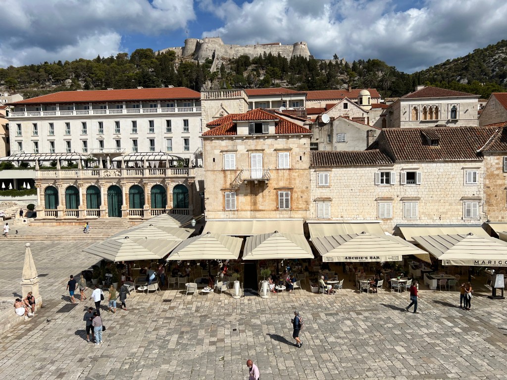 View of St Stephen's Square on Hvar island in Croatia. The fortica sits high above the town.